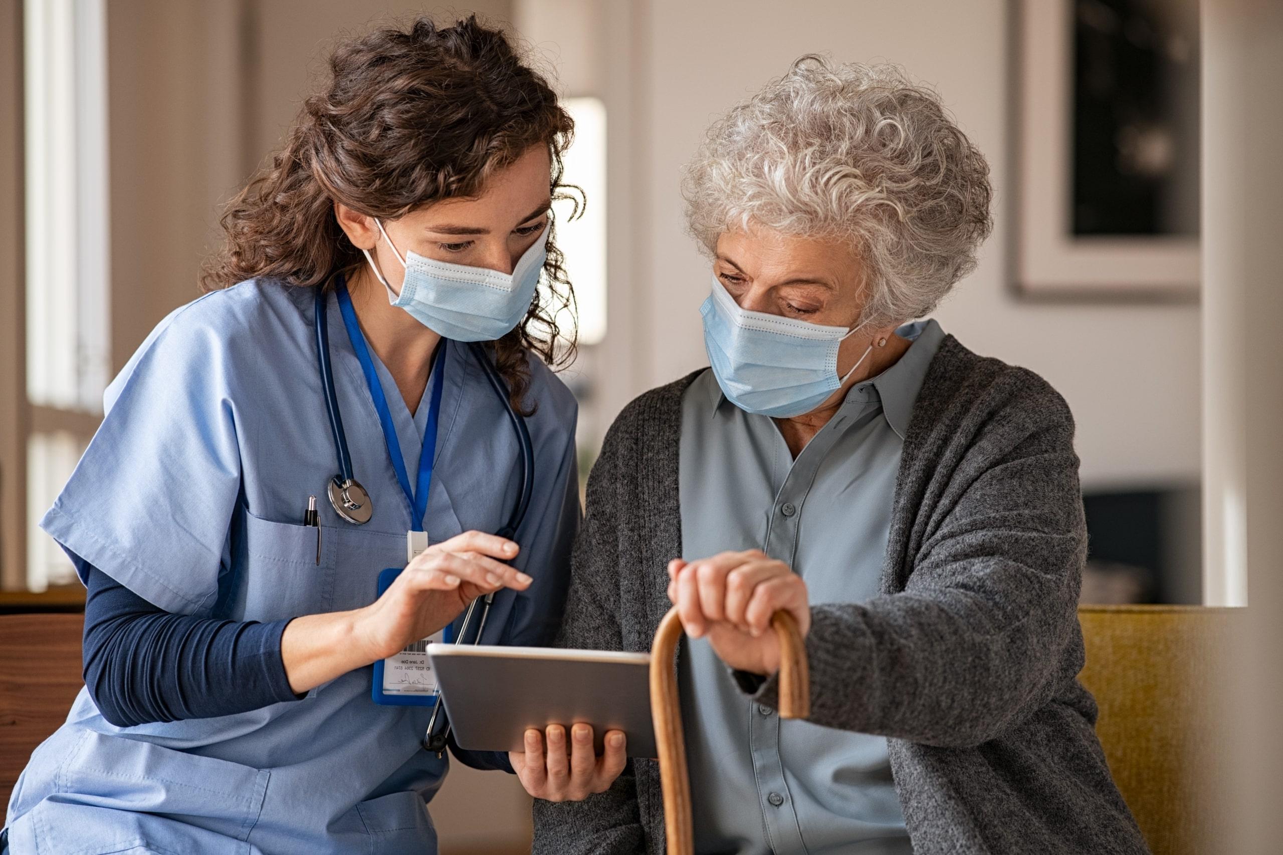 Medical professional and senior woman looking at tablet